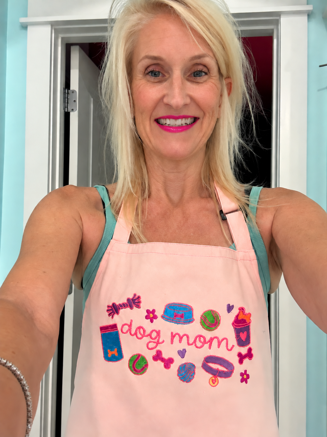 Cinda wearing a colorful embroidered dog mom apron