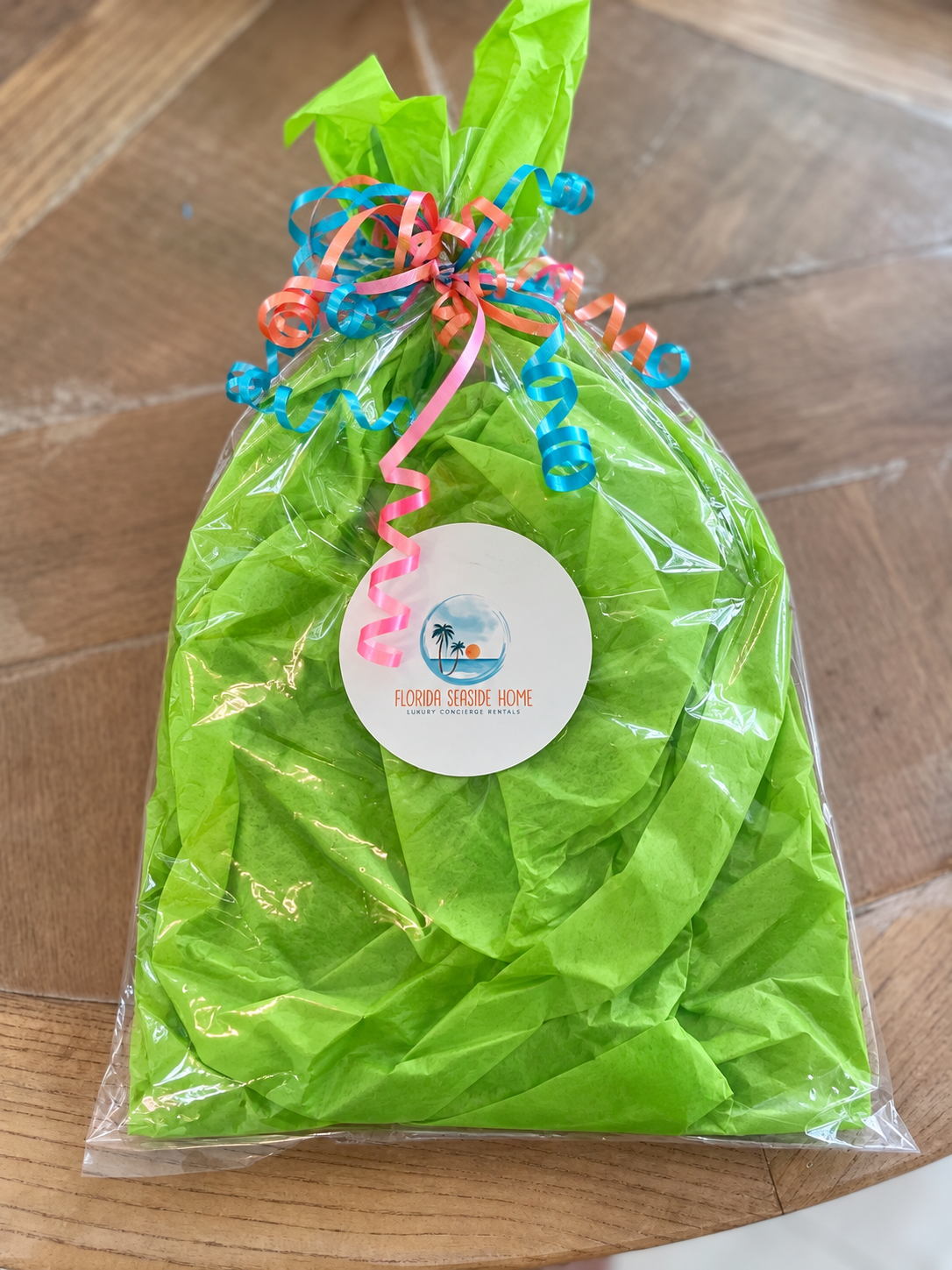 Florida Seaside Home gift wrapped in lime green tissue and clear cellophane with colorful curling ribbons