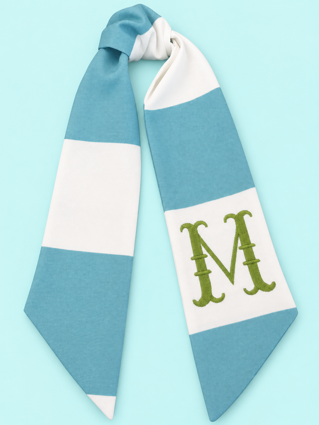 Blue and white wreath sash with a green M monogram on a baby turquoise background