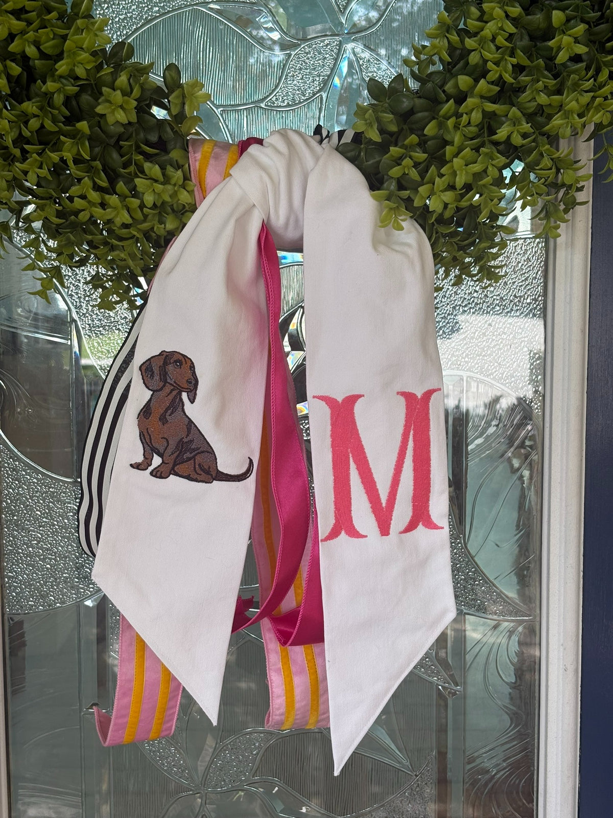 Close-up of an embroidered dachshund wreath sash